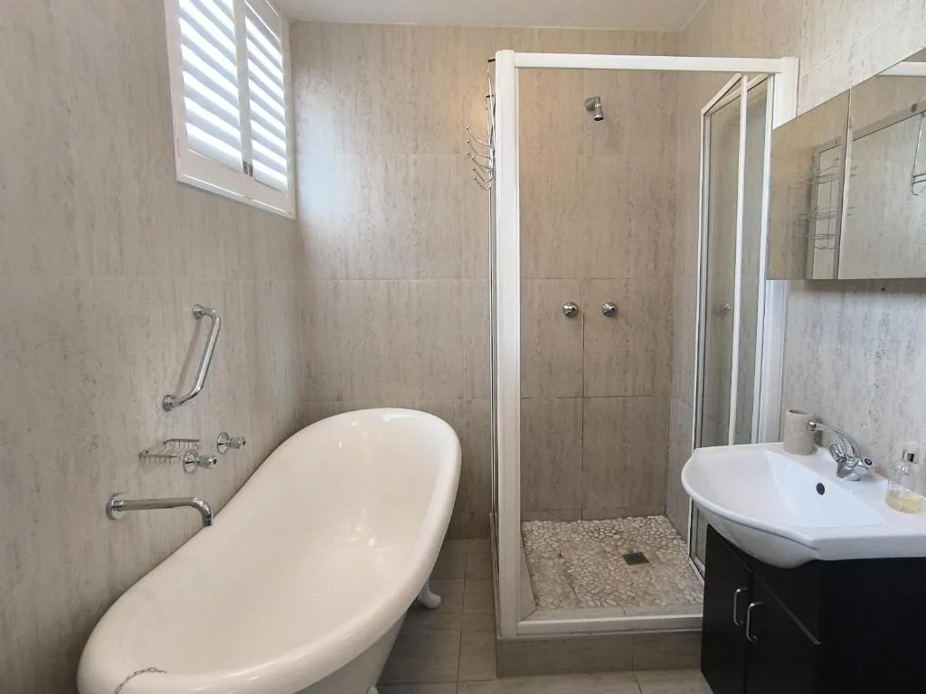 Bathroom with a freestanding tub and a separate glass-walled shower