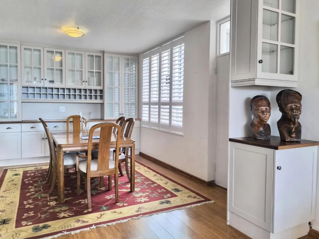 Dining nook with glass-fronted cabinetry, built-in wine rack shelving and a wooden table