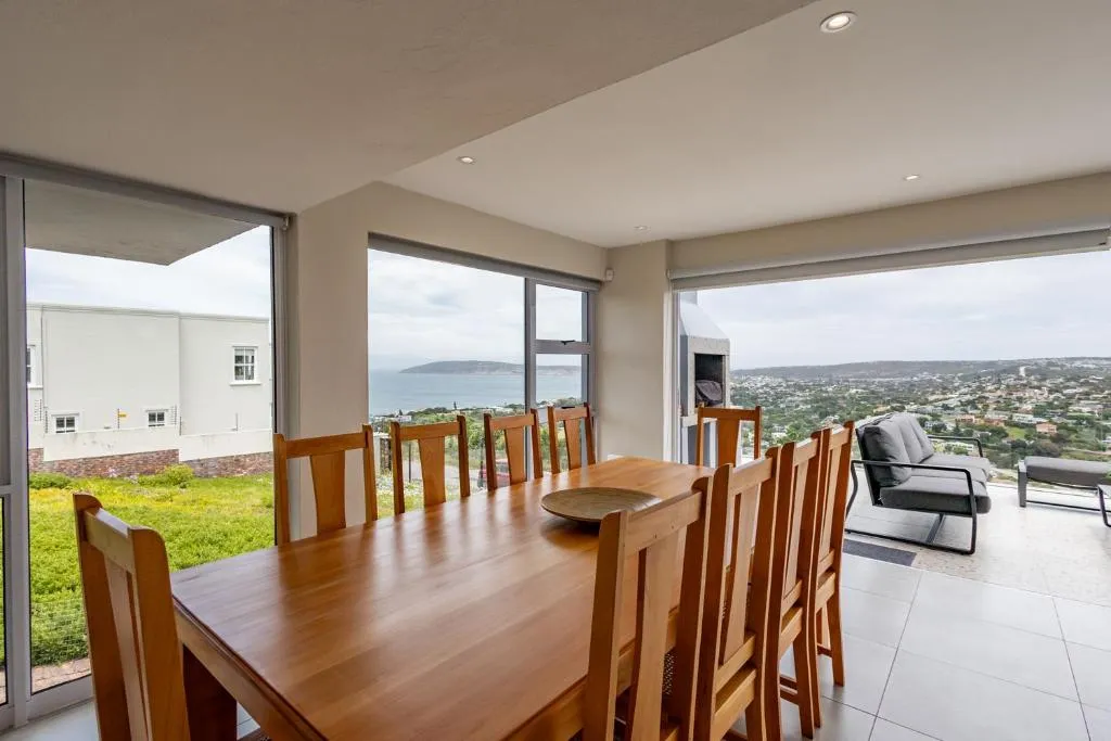 Dining table for ten with a sea view of Robberg headland through floor-to-ceiling windows