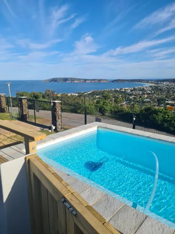 Raised swimming pool overlooking Robberg headland and Plettenberg Bay with mountains behind