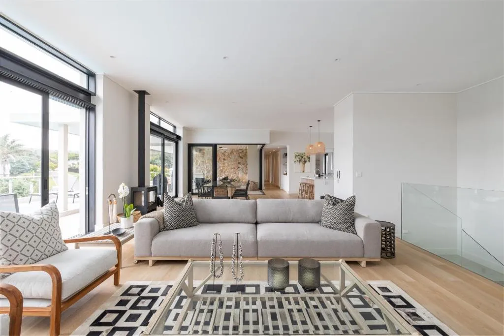Open-plan lounge with a wood-burning fireplace and floor-to-ceiling glass doors