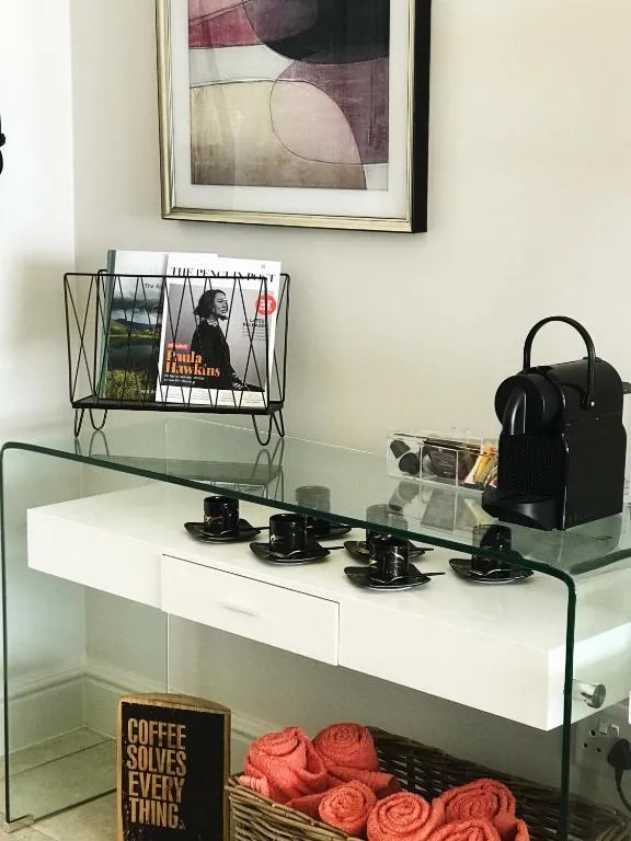 Coffee station with a pod machine, magazines and a basket of rolled towels