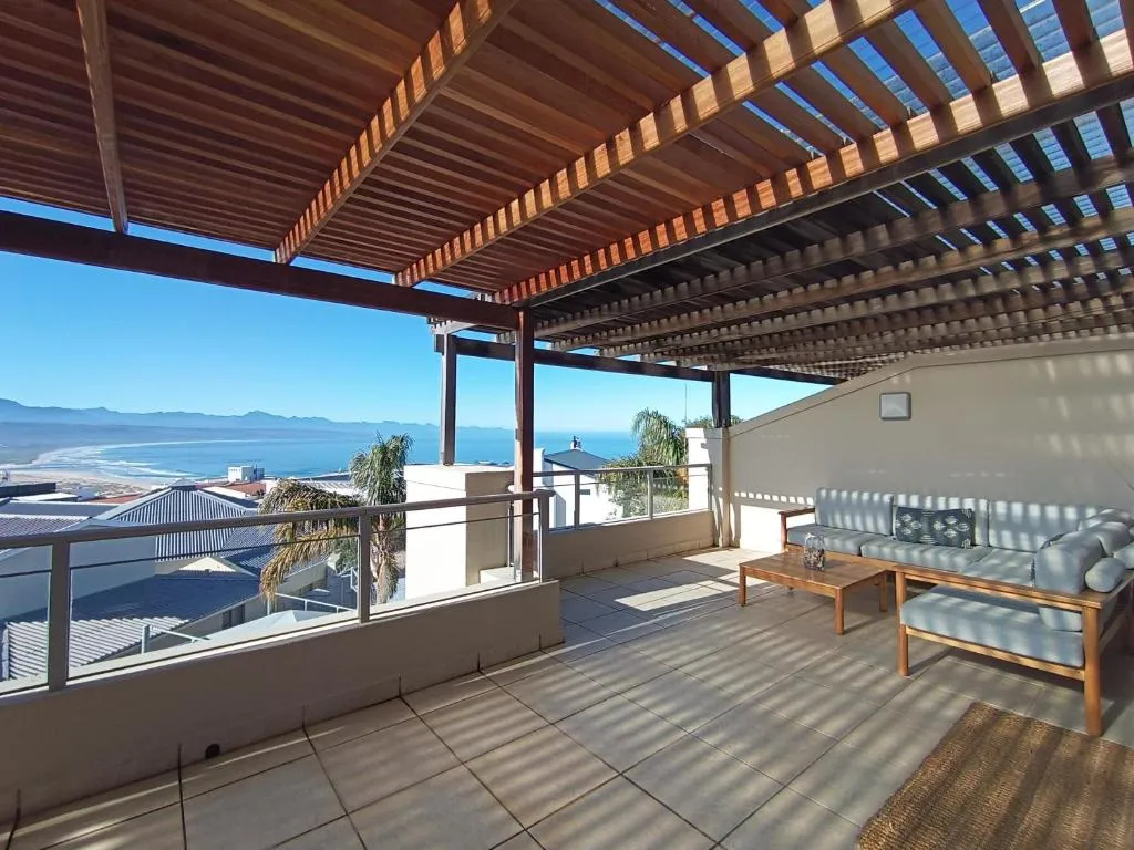 Second pergola terrace with lounge seating looking out over the ocean and mountains
