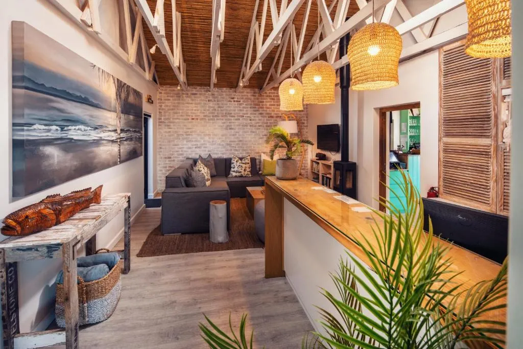 Lounge with a grey corner sofa, wood-burning stove and reclaimed timber bar counter