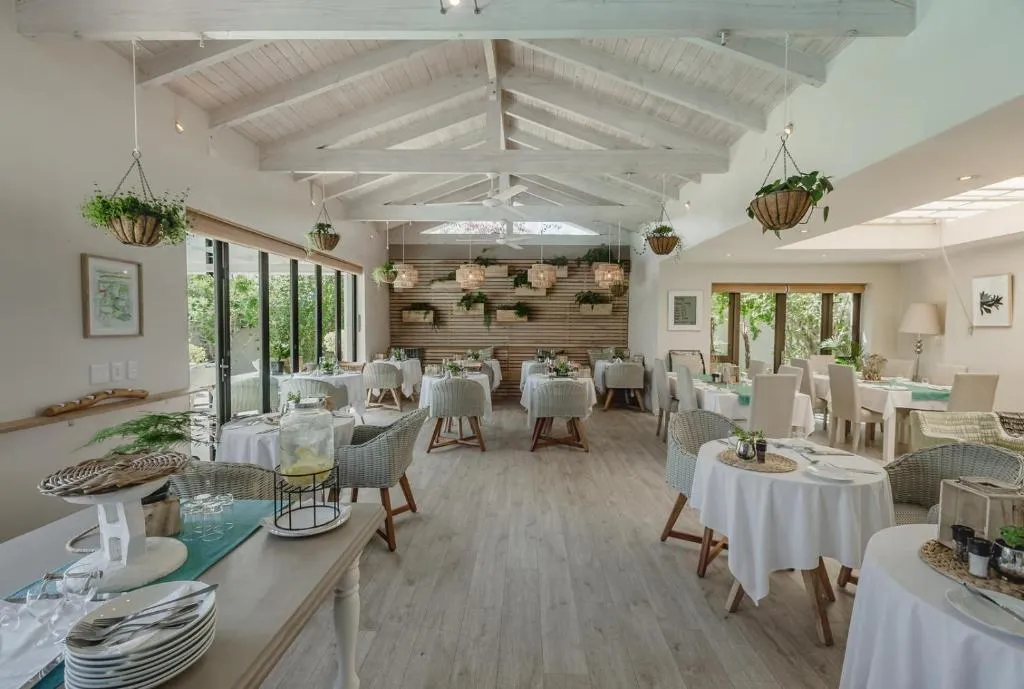 Vaulted dining room set for breakfast with hanging plant baskets and skylights