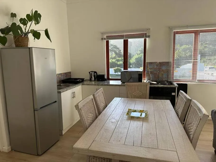Kitchen and dining table with fridge, gas stove and a window over the garden