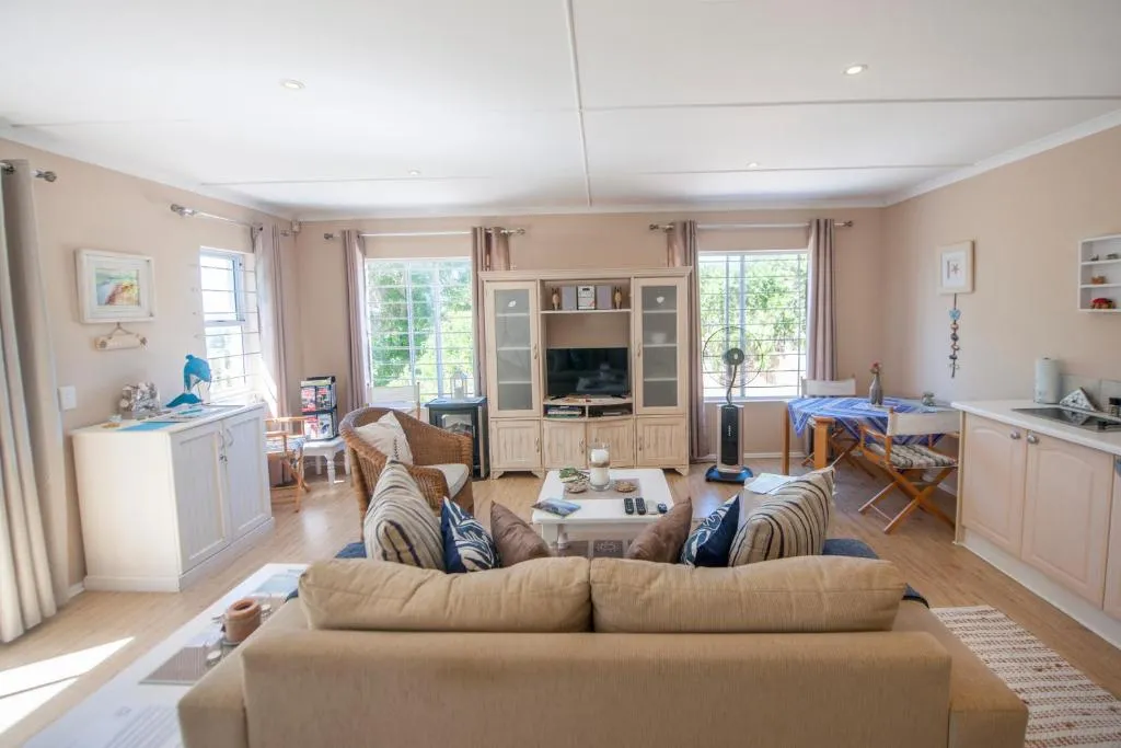 Second view of the lounge with wicker armchair, TV unit, and dining nook