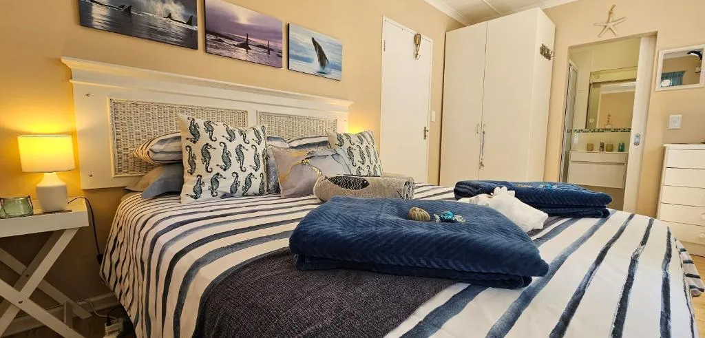 Nautical-themed bedroom with whale prints, striped bedding, and bedside lamps