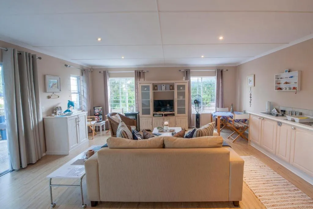 Open-plan lounge, dining, and kitchen with a wood-burning stove and large windows