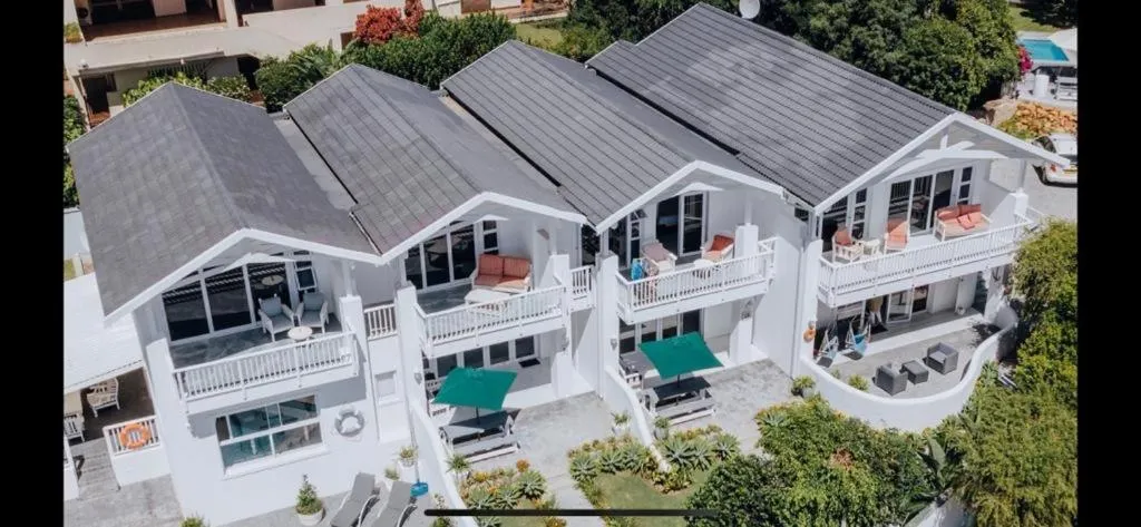 Aerial view of the building's dark-tiled roofline and balconies with outdoor cushions among rooftops
