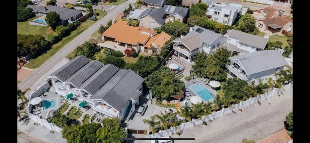 Wide aerial view of the property amid surrounding streets and neighbouring homes in Plettenberg Bay