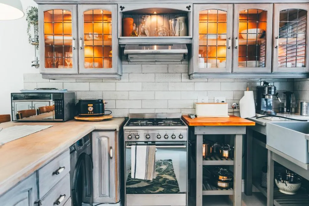 Country-style kitchen with glass-fronted cabinets, a gas stove and a butcher-block island