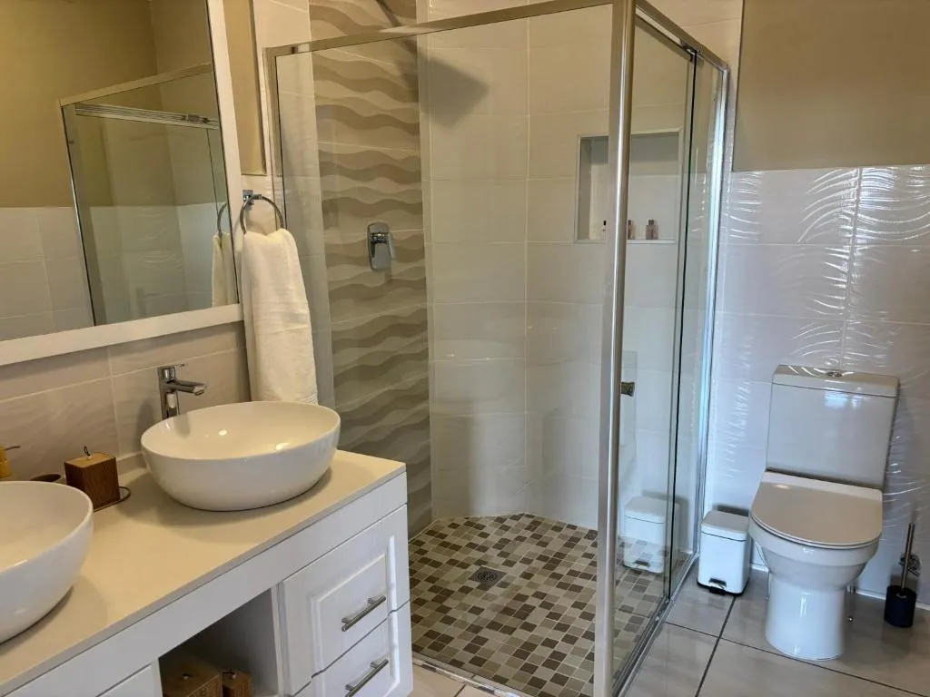 Bathroom with double vessel basins and a separate glass-walled shower