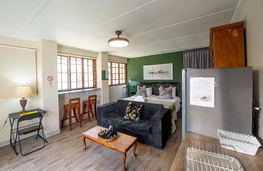 Self-catering studio with a bed, sofa, bar seating at a window counter and a bar fridge