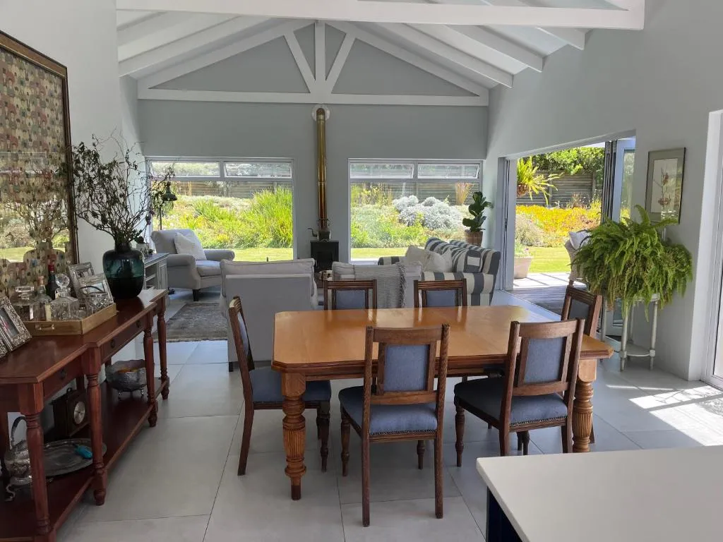 Open-plan dining and living area with a wood burner, French doors opening onto the garden