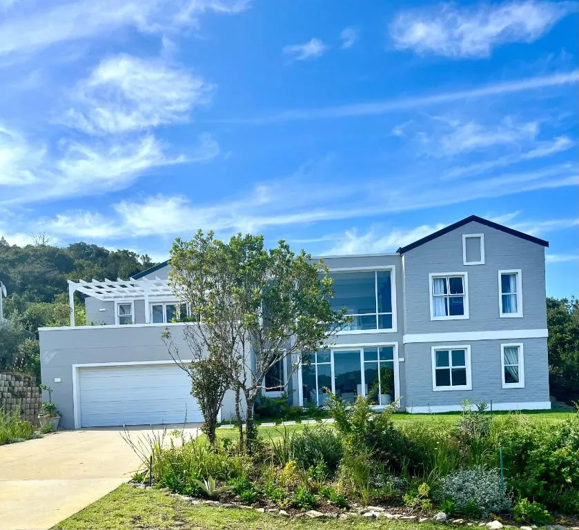 Front elevation of the double-storey house with a landscaped garden, pergola and double garage