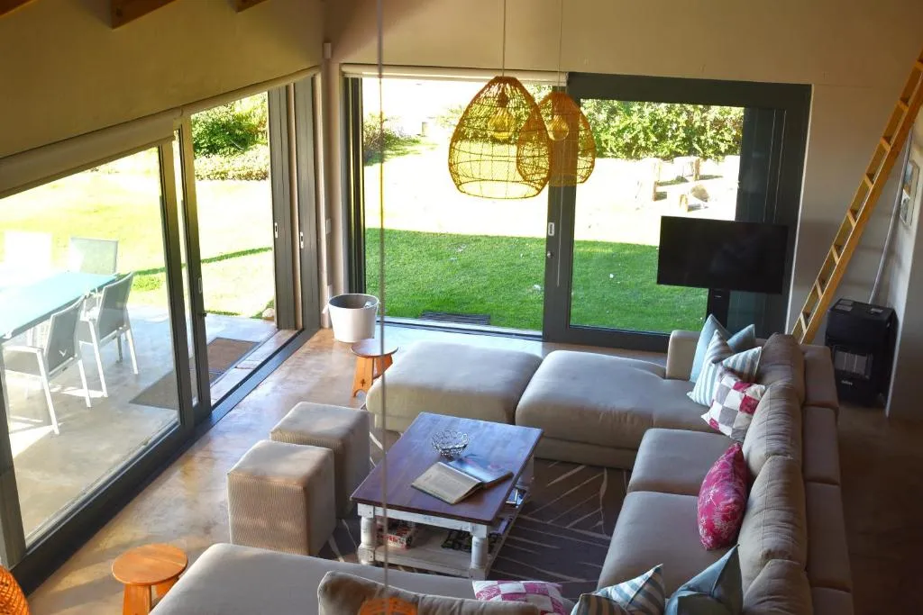 Second living area with hanging pendant lights and glass doors opening onto the outdoor dining terrace