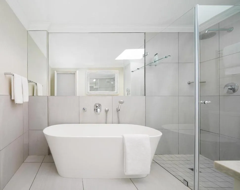 Bathroom with a freestanding tub, walk-in shower and a skylight