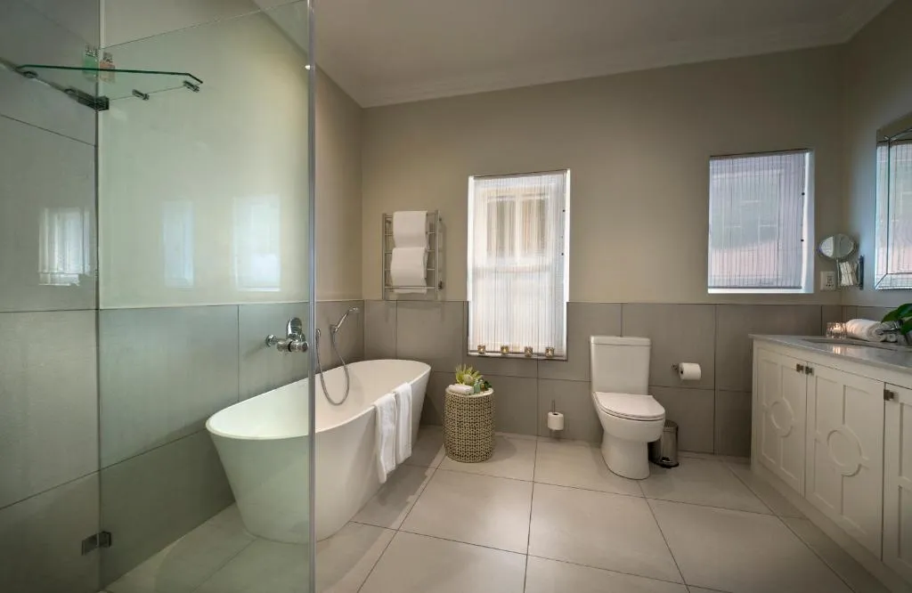 Bathroom with a freestanding tub, separate shower and a curtained window