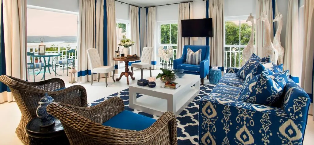 Suite living room in blue and white with a private balcony overlooking the lagoon