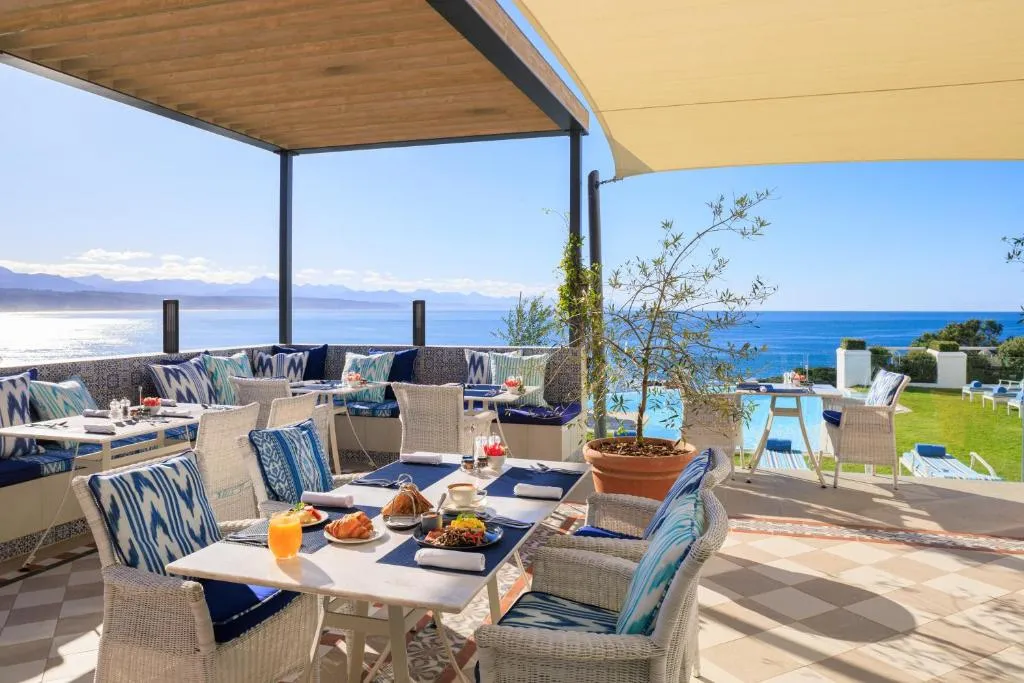 Breakfast laid on a shaded terrace with the pool and open ocean beyond