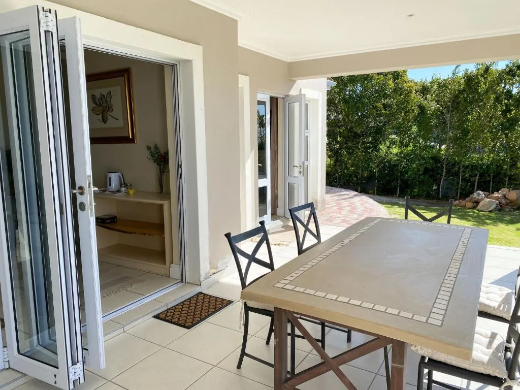 Second covered patio with a stone dining table beside sliding doors into a guest room