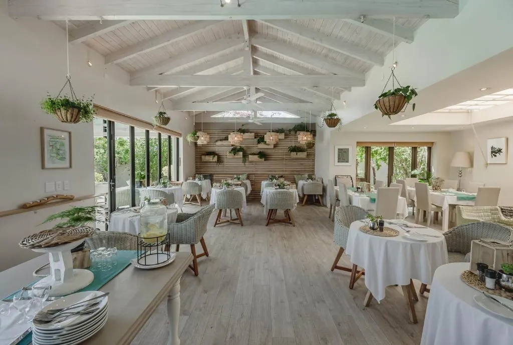 Restaurant dining room with timber-beamed ceiling and hanging plants