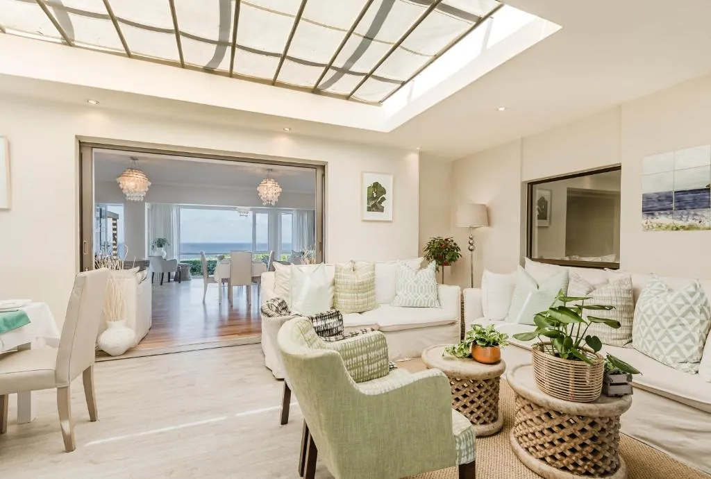 Living room opening onto a dining area with a glimpse of the sea