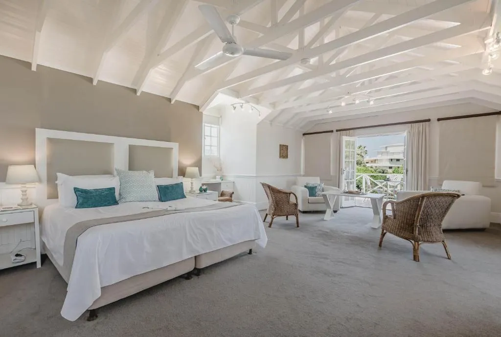Vaulted-ceiling suite with a king bed and a separate seating area onto a balcony