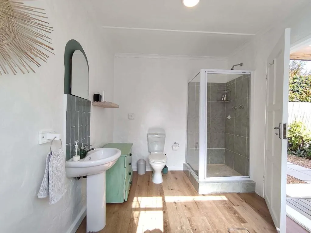 Bathroom with a mint-green vanity, pedestal basin and a separate glass shower stall