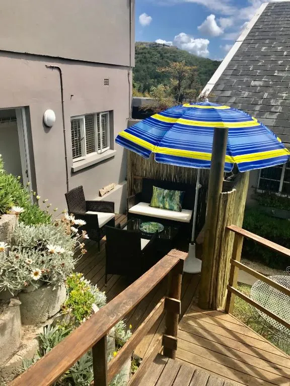 Umbrella-shaded deck table overlooking a mountain and forested hillside