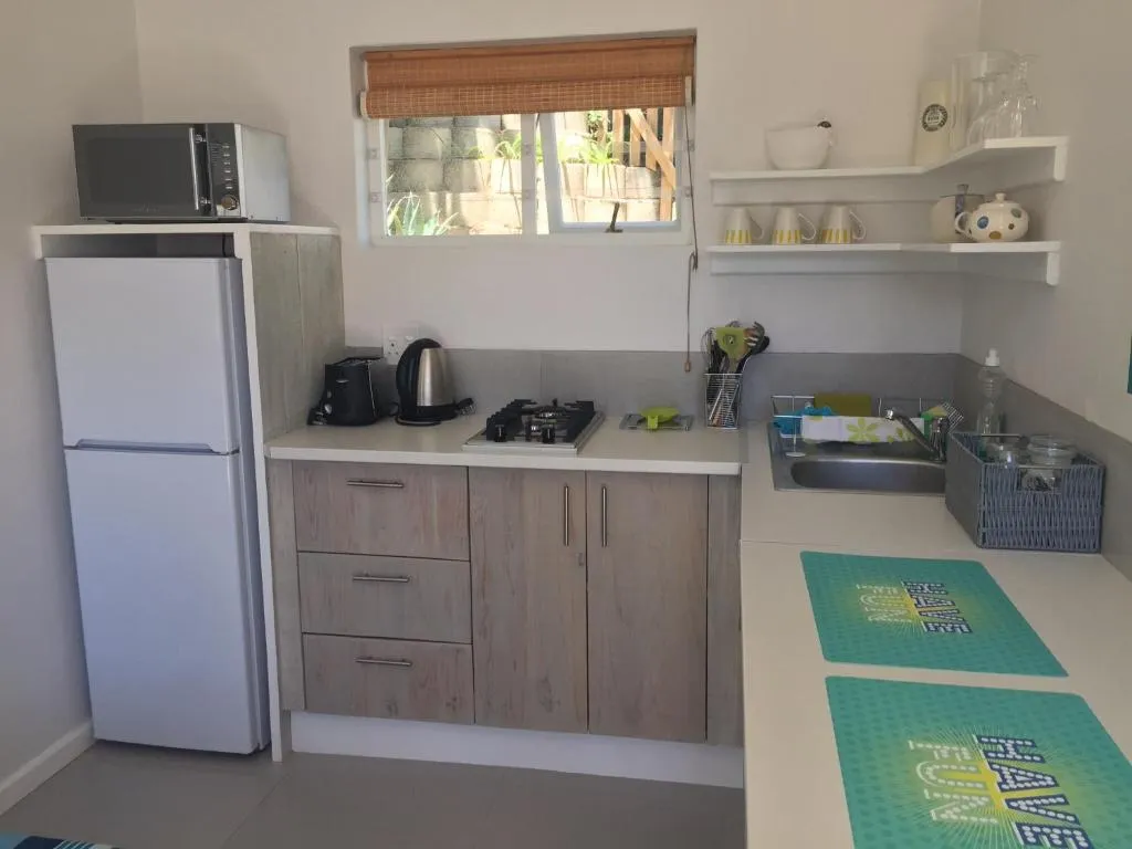 Compact kitchenette with fridge-freezer, two-plate gas hob and open shelving