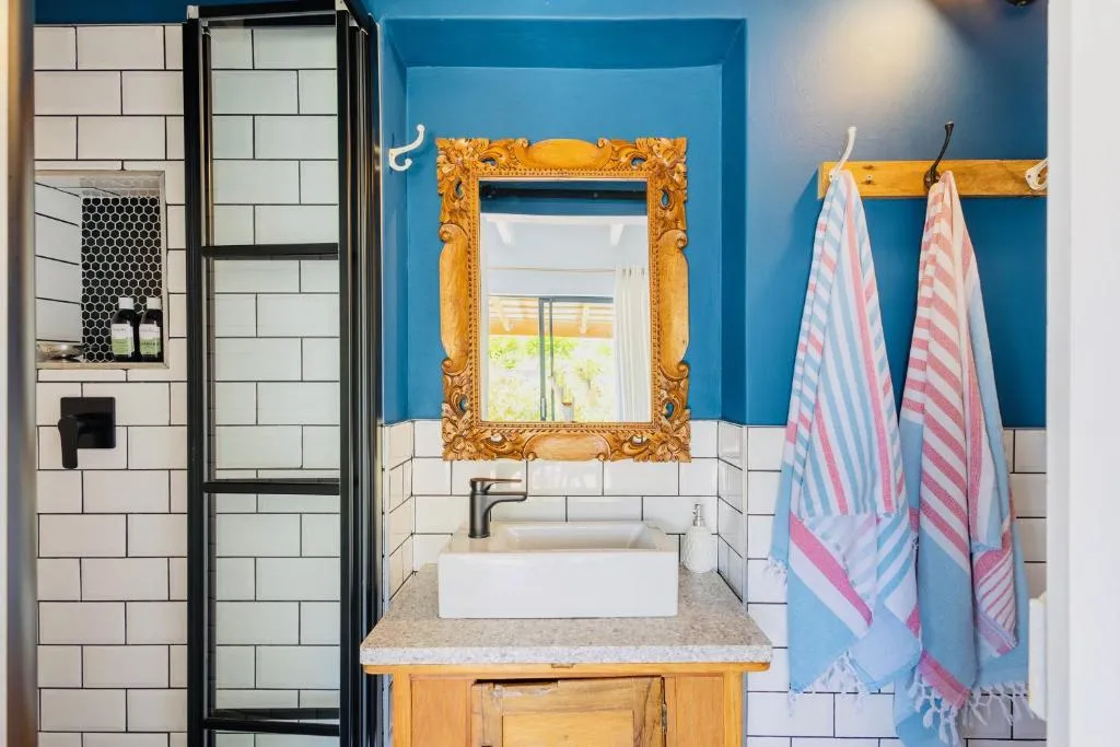 En-suite bathroom with a walk-in shower, subway tile and a carved wooden mirror frame