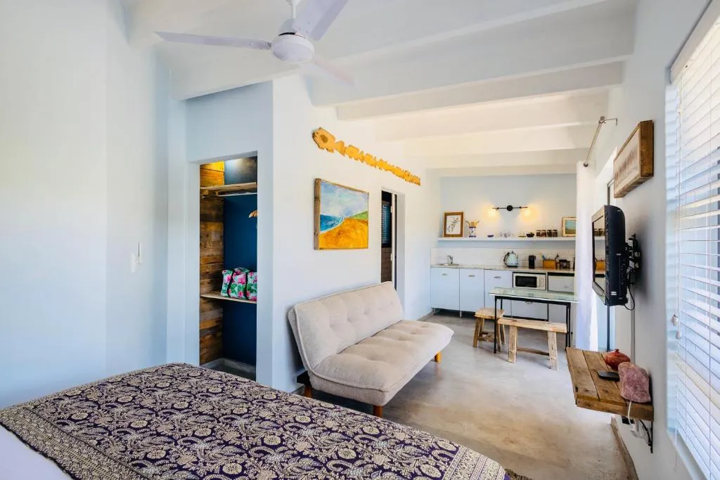 Studio's open living area with a compact kitchenette, sofa and overhead fan