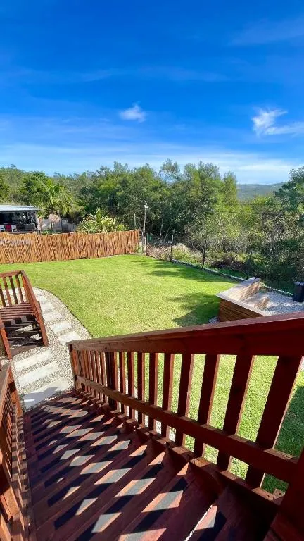 View from the wooden deck over a lawned garden towards distant hills