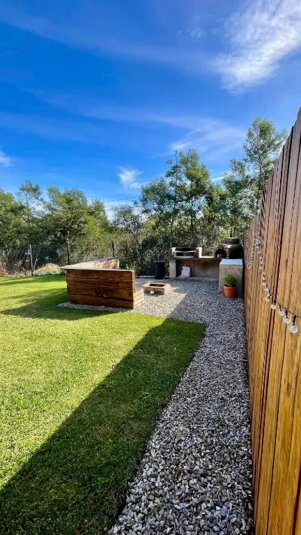 Outdoor braai area with a built-in pizza oven and stone braai station on gravel