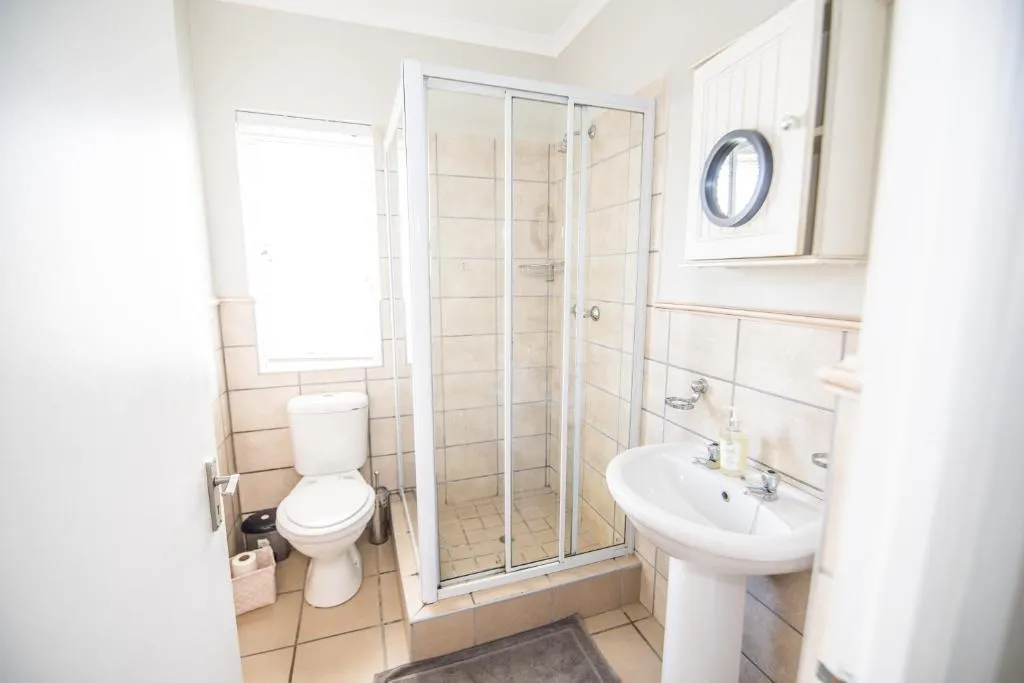 Bathroom with a glass shower cubicle, pedestal basin and toilet