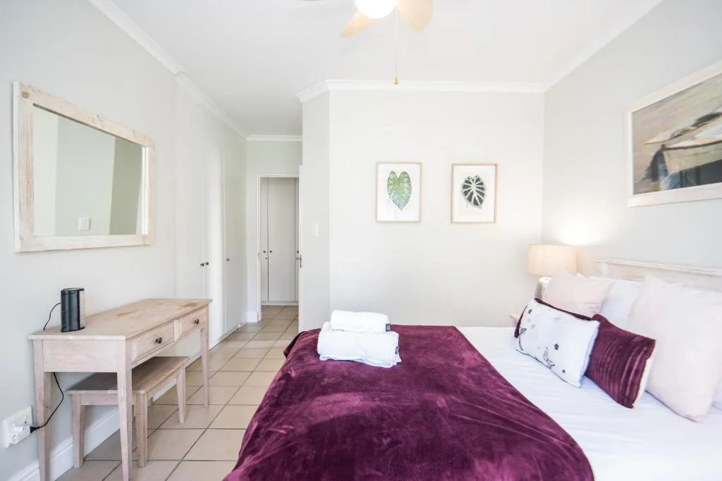Second bedroom with a hallway to built-in closets and a dressing mirror and desk