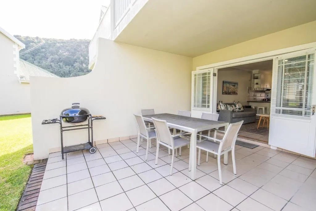 Covered patio with a Weber braai and outdoor dining table opening onto the lounge