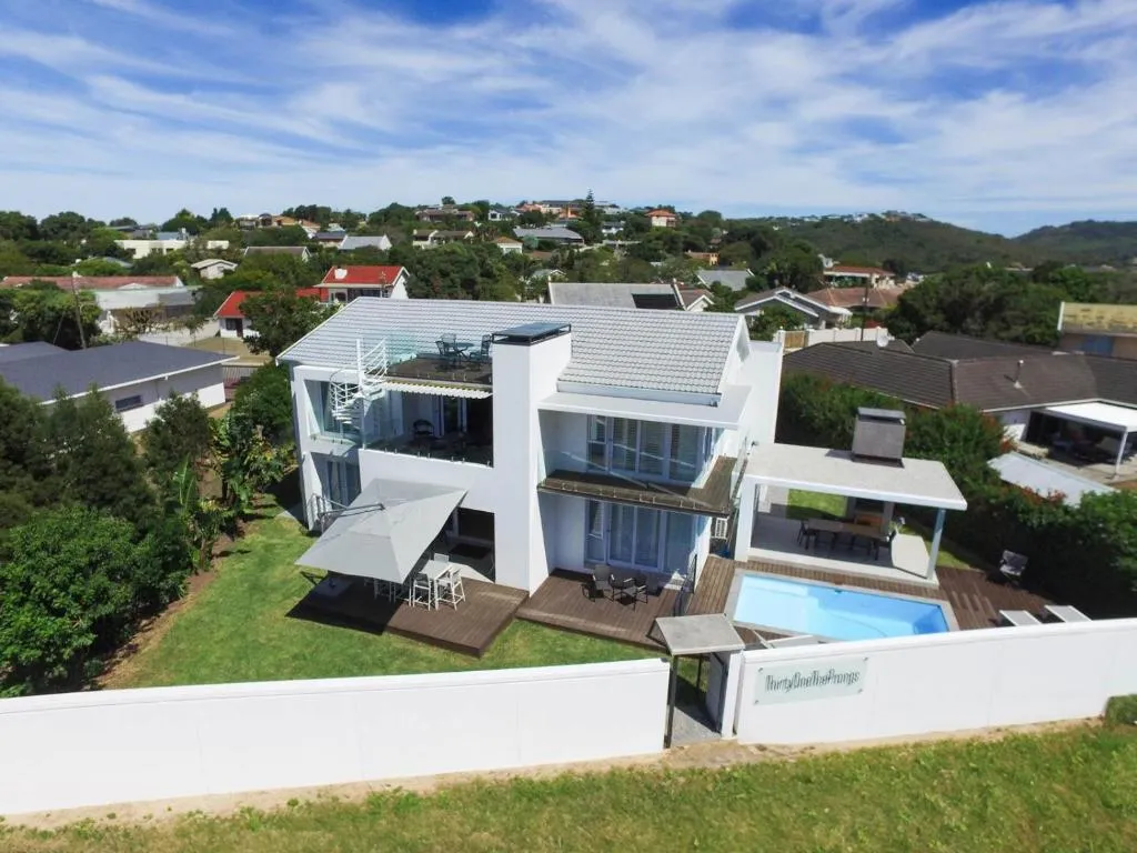 Aerial view of the property's pool, lawn and entertainment deck behind a boundary wall