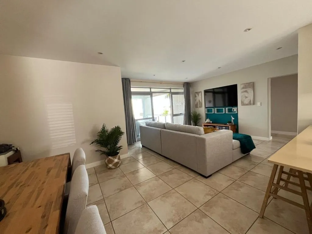 Second view of the lounge with sectional sofa, TV unit, and sliding doors