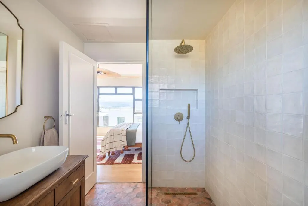 Ensuite bathroom with a walk-in glass shower and a doorway view through to the bedroom