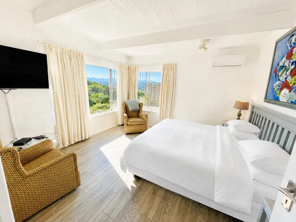 Bedroom with mountain views through twin windows, wall-mounted air conditioning and a TV
