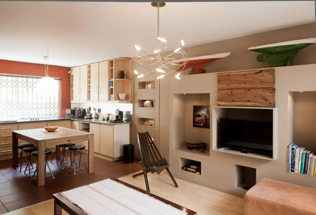 Open-plan kitchen and dining area with a red feature wall and wooden table