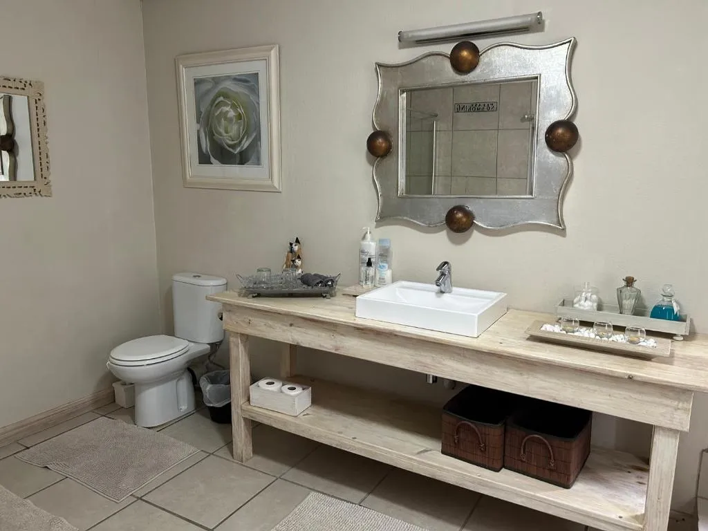En-suite bathroom with a rustic wooden vanity table and ornate silver mirror