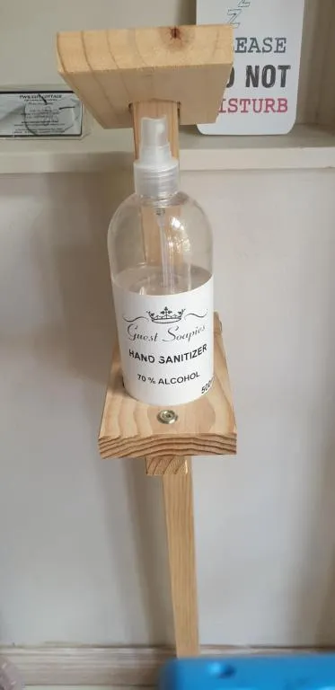 Wall-mounted hand sanitizer dispenser labelled for guest use