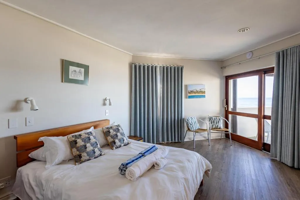 Bedroom with sliding doors opening onto a balcony facing the open sea
