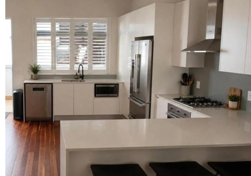 Galley kitchen with white cabinetry, a gas hob and full-height stainless fridge