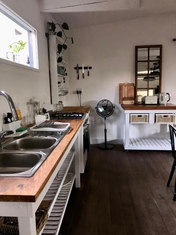 Galley kitchen with butcher-block counters, gas hob and a double stainless steel sink