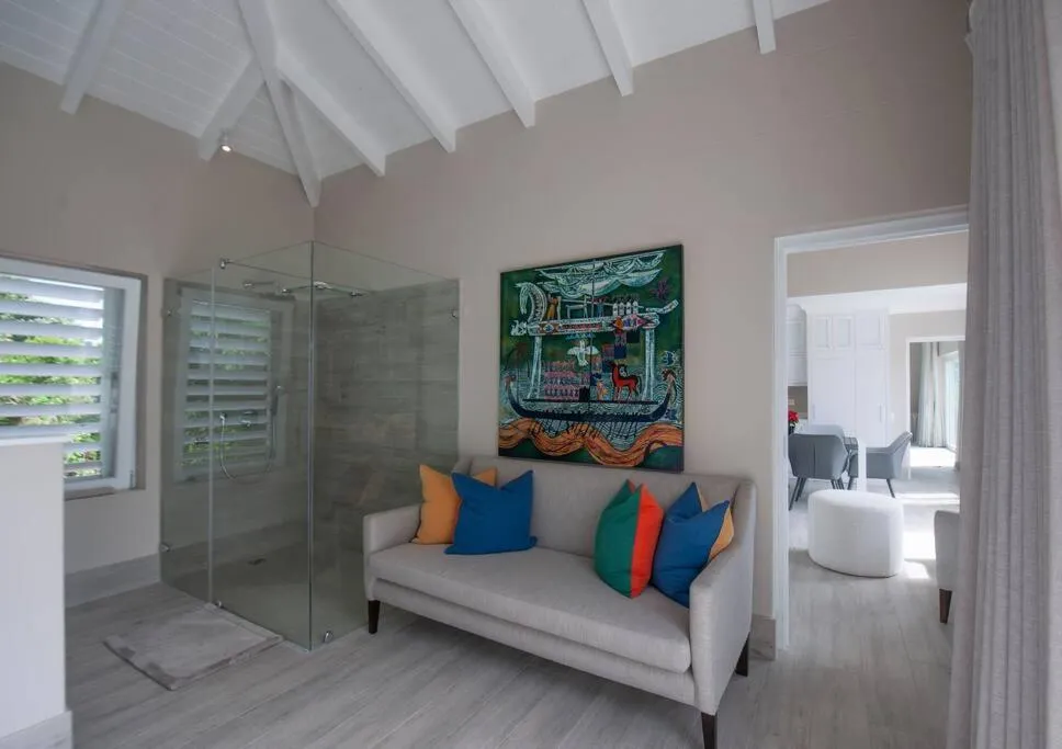 Bedroom sitting area with vaulted ceiling, sofa and glass-enclosed shower alcove